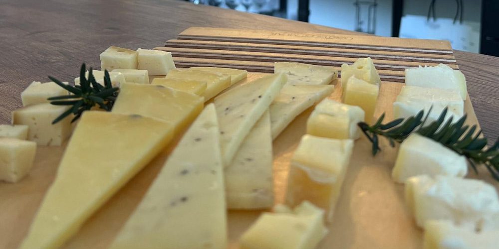 Tabla de quesos cortados listos para maridar con vino.